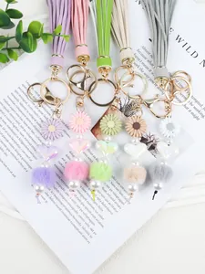 Détails des porte-clés à glands faits main avec des marguerites et des pompons