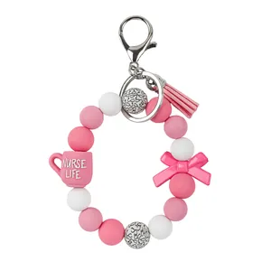 Pink and white silicone beaded wristlet keychain with nurse life cup and bow charms