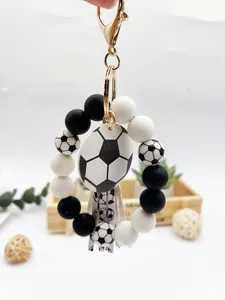 Detalle del llavero de fútbol con cuentas de silicona, placa de madera y borla.