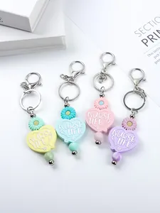 Close-up view of colorful silicone heart keychains with daisy and Nurse Life text