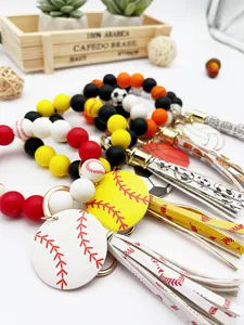 Primer plano de pulseras llavero de cuentas de silicona con colgantes de béisbol y fútbol.
