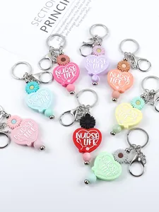 Detailed close-up of various colorful NURSE LIFE silicone heart keychains with daisy beads
