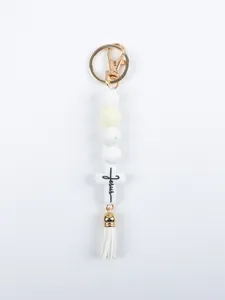 Close-up of a white silicone beaded keychain featuring a cross with 'Jesus' text.