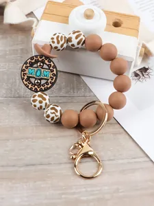 Dettaglio ravvicinato di un portachiavi a bracciale in silicone leopardato con gancio dorato