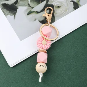 Détail du porte-clés en perles de silicone rose avec perle en bois gravée LOVE.