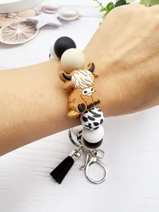 Detailed view of the highland cow silicone bead keychain bracelet worn on a female wrist