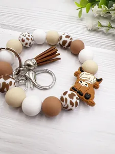 Detailed shot of a highland cow silicone bead keychain bracelet with brown tassel