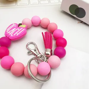 Pink silicone beaded keychain wristlet with teacher apple charm and tassel.