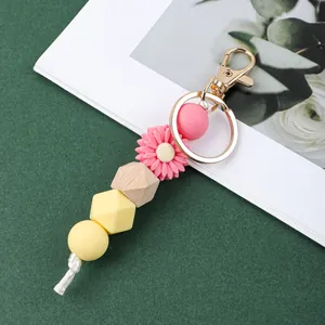 Détail d'un porte-clés marguerite fait main en perles de silicone et bois doré