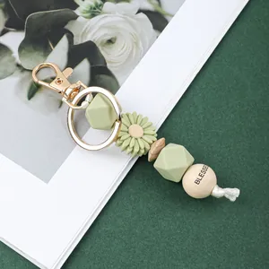 Détail du porte-clés en perles de silicone avec marguerite verte et perle Blessed