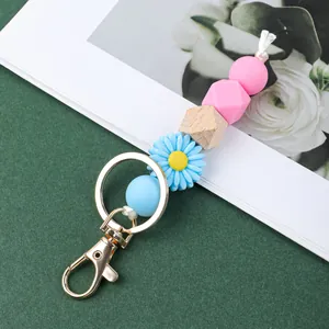 Vue détaillée d'un porte-clés avec perles en silicone et marguerite, fermoir doré