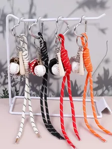 Dettaglio di portachiavi da baseball intrecciati a mano in quattro colori con mini accessori