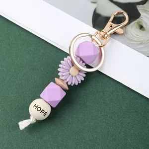 Vue détaillée d'un porte-clés en perles de silicone avec fleur marguerite et perle HOPE.