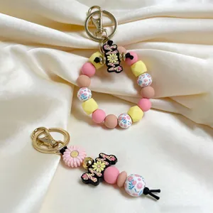 Detailed view of silicone beaded keychain with daisy charm and floral octagon beads