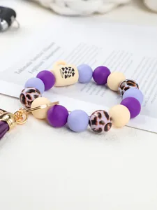 Close-up of leopard silicone bead wristlet keychain with cup charm and purple tassel