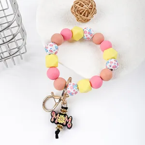 Detail of silicone beaded wristlet keychain with floral beads and MOM daisy charm