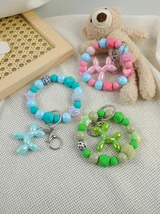Macro detail of colorful beaded wristlets with balloon dog charms in cute styling.