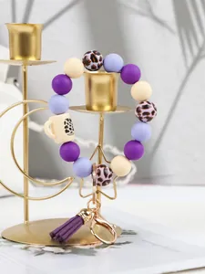 Detailed view of leopard print silicone bead keychain with purple tassel and cup charm