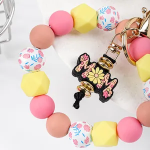 Detailed view of a silicone beaded keychain with a floral MOM charm and daisy beads.