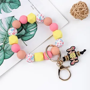 Detail view of silicone bead keychain bracelet with daisy charm and floral prints