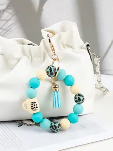 Close-up of teal and leopard print silicone bead wristlet keychain with a small tassel