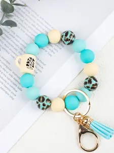 Close-up detail of a leopard print silicone bead keychain with a mini coffee cup charm.