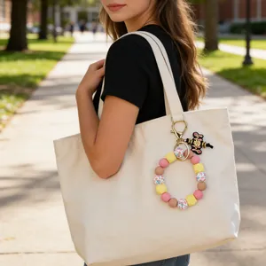 Colorful silicone floral beaded keychain wristlet bracelet shown on canvas tote bag