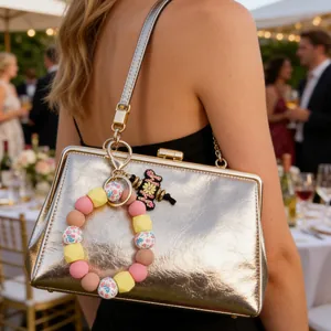 Charming floral silicone bead keychain wristlet and daisy bag charm on golden clutch bag