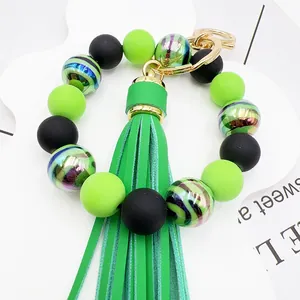 Close-up of green and black zebra stripe beaded bracelet keychain with tassel detail.