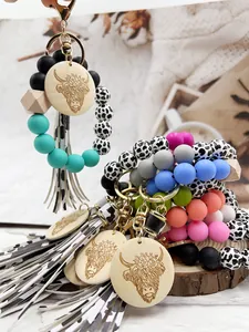 Detail of Western style cow print silicone bead keychains with engraved wood discs.