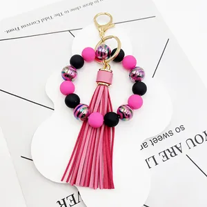 Detail of pink and black beaded bracelet keychain with zebra stripe beads and tassel.