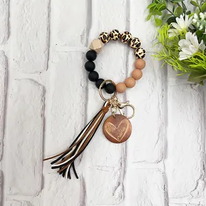 Detail view of silicone bead keychain with leopard print, tassel, and Mama wood charm