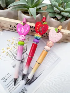 Close-up of beaded pens with TEACH apple charms and sparkling rhinestone balls