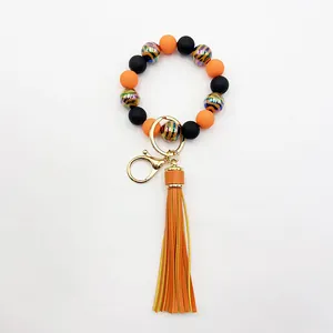 Detail view of handmade zebra stripe beaded wristlet keychain with orange leather tassel