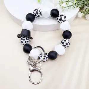 Vista dettagliata del bracciale in perle di silicone stile Western con motivo mucca e cappello.