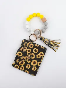 Close-up of beaded wristlet keychain with sunflower PU leather wallet and tassel