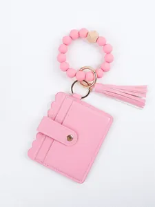 Macro view of pink silicone bead bracelet keychain with PU leather card holder and tassel