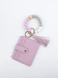 Close-up of lavender PU leather card holder with beaded silicone wristlet and tassel.