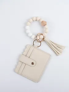 Close-up of beige PU leather card wallet with beaded wristlet and tassel detail