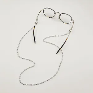 Vue détaillée d'une chaîne de lunettes en perles faite main sur des lunettes.