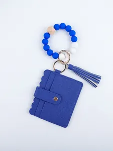 Close-up of blue PU leather card holder with silicone bead wristlet and tassel accent