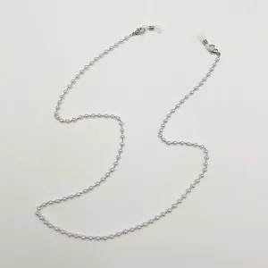 Gros plan d'un cordon à perles argentées pour lunettes et masques avec fermoirs mousquetons.