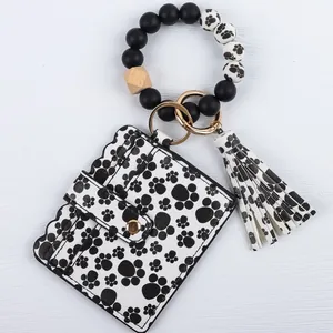 Black and white bead wristlet keychain featuring a paw print card wallet and tassel