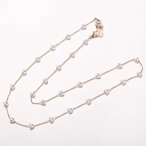 Élégante chaîne de lunettes cœur perle maillons dorés fond blanc