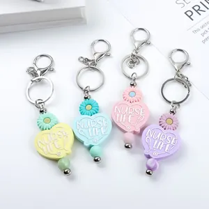 Cute silicone heart keychains with Nurse Life engraving and daisy beads in pastel colors.