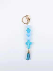 Close-up of a blue silicone beaded keychain featuring a cross pendant and tassel.