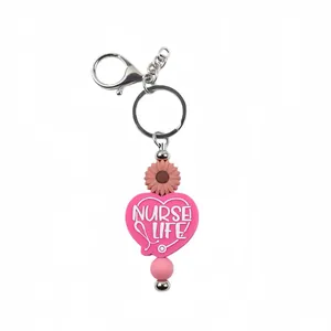 Pink silicone heart keychain featuring "Nurse Life" text and daisy bead ornament for bags