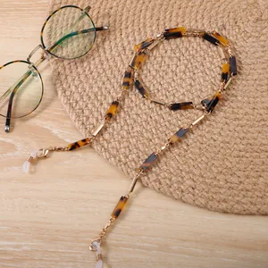Dettaglio della catena per occhiali in acrilico leopardato con maglie dorate.