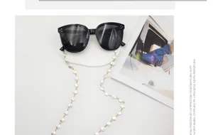 Detailansicht einer eleganten weißen Perlen-Brillenkette mit goldenen Verbindungen