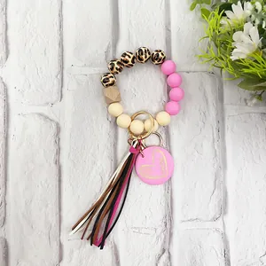 Detailed view of leopard silicone bead keychain with tassel and pink heart mama charm